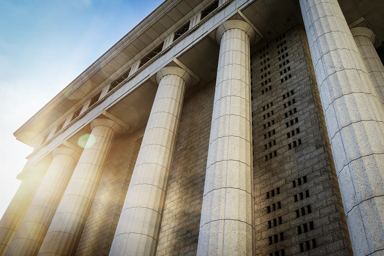 Fachada de un edificio público con columnas, símbolo de las compras estatales